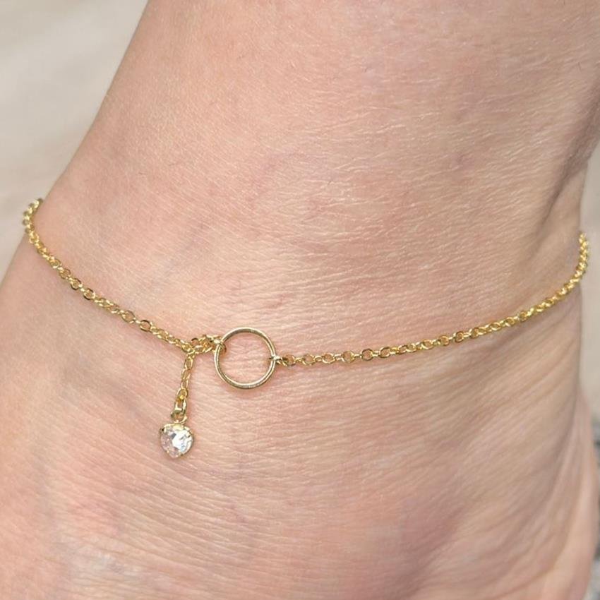 TORNOZELEIRA ELO BAILARINA CENTRO EM ARO REDONDO LISO VAZADO COM PENDENTE EM PONTA CORAÇÃO CRISTAL | BANHADO EM OURO 18K